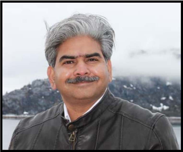 Dr. Surendra Chavan outdoors near a lake and mountains